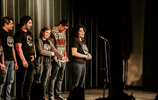 Students standing on a stage.