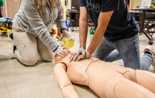Two People Performing CPR on a Manikin