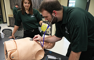 Male and female EMT students learning