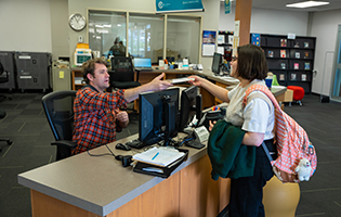 Library staff helping a student