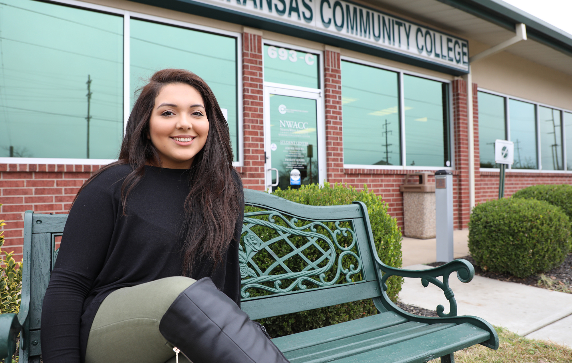 Female Hispanic student sitting outside on a bench